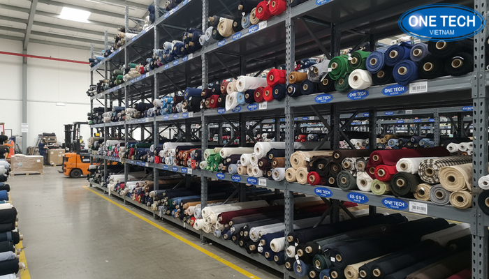 Minh họa kệ kho dạng module có gắn nhãn vị trí để quản lý vải và tồn kho